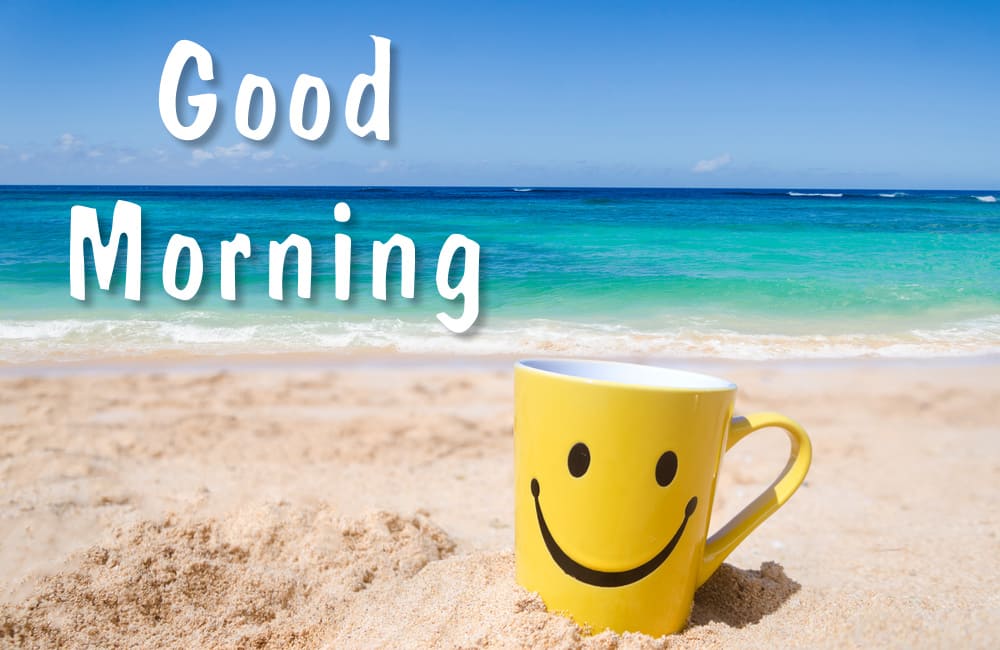 Yellow cup with a smile on the sandy shore of a beautiful sea.